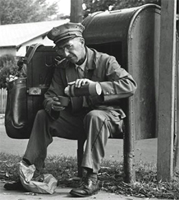 Vintage mailman sitting in post box.